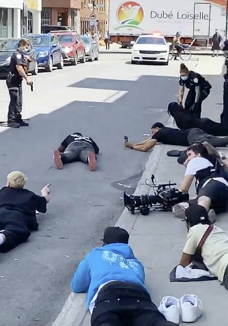 Des policiers du Service de police de la Ville de Montréal demandent à une équipe de tournage de se coucher au sol pour vérifier les fausses armes sur les lieux.
