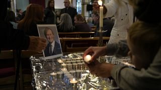 مصلون يقيمون صلاة لراحة نفس ديفيد أميس 