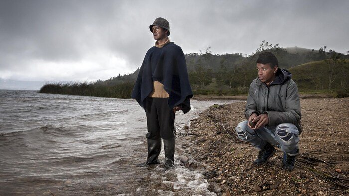شخصان جالسان على شاطئ.